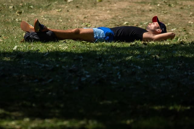 A man sunbathes in St James Park, London (Dominic Lipinski/PA)