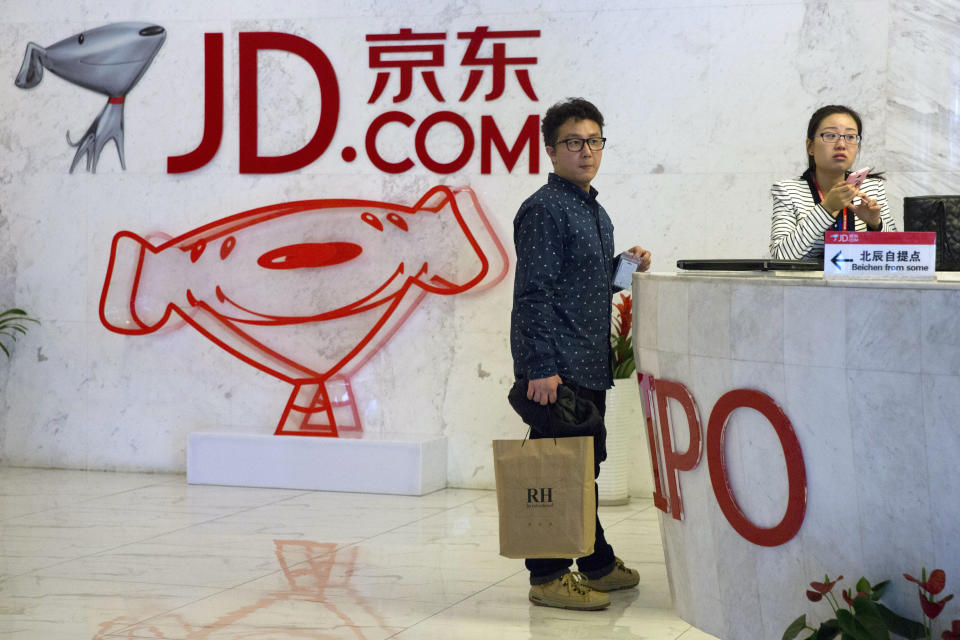 In this photo taken April 2, 2015, visitors wait at the entrance to JD.com head office in Beijing. Since it went online in 2003, JD.com has grown into China’s biggest Internet-based direct retailer. It is a powerful selling point for Chinese consumers who have endured repeated scandals over fake and sometimes deadly milk, medicines and other products. (AP Photo/Ng Han Guan)