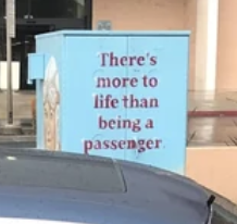 Utility box with the phrase "There's more to life than being a passenger" written on it