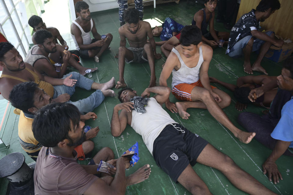 Rohingya refugees rest on the deck of a National Search and Rescue Agency ship, after being rescued from their capsized boat in the waters off West Aceh, Indonesia, Thursday, March 21, 2024. An Indonesian search and rescue ship located a capsized wooden boat that had been carrying dozens of Rohingya Muslim refugees, and began pulling survivors who had been standing on its hull to safety Thursday. (AP Photo/Reza Saifullah)