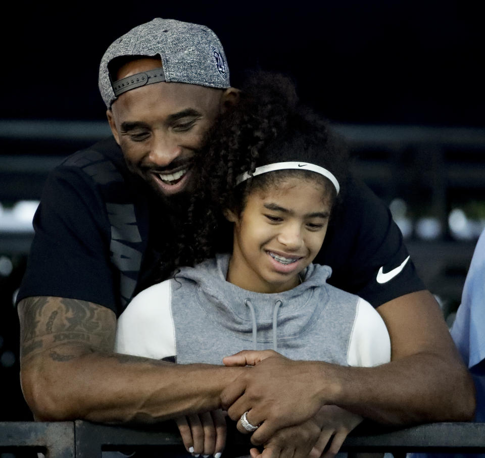 Former Los Angeles Laker Kobe Bryant and his daughter Gianna watch during the U.S. national championships swimming meet Thursday, July 26, 2018, in Irvine, Calif. (AP Photo/Chris Carlson)