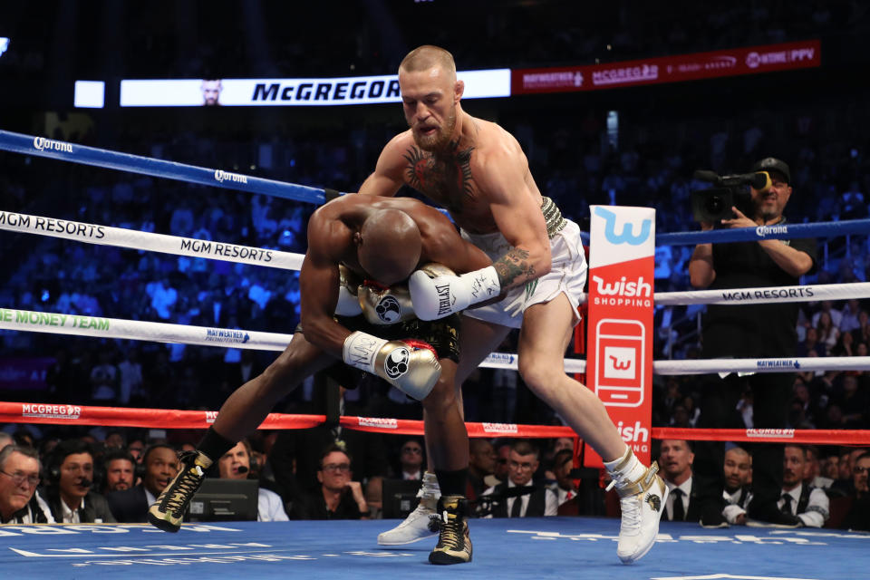 LAS VEGAS, NV - AUGUST 26:  (R-L) Conor McGregor throws a punch at Floyd Mayweather Jr. during their super welterweight boxing match on August 26, 2017 at T-Mobile Arena in Las Vegas, Nevada.  (Photo by Christian Petersen/Getty Images)