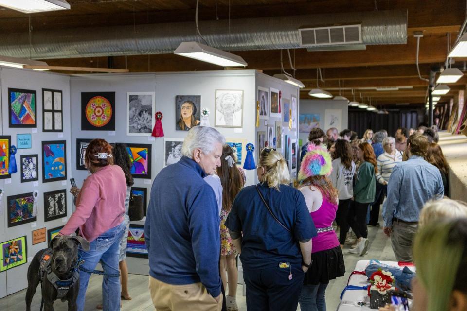 Visitors stroll through the Gallery on Tuesday, March 26, at Loray Mill.