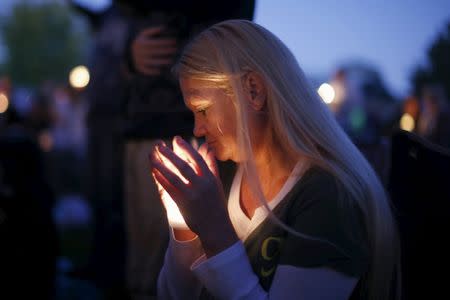 A woman takes part in a candlelight vigil for victims of the Umpqua Community College shooting, in Winston, Oregon, United States, October 3, 2015. REUTERS/Lucy Nicholson