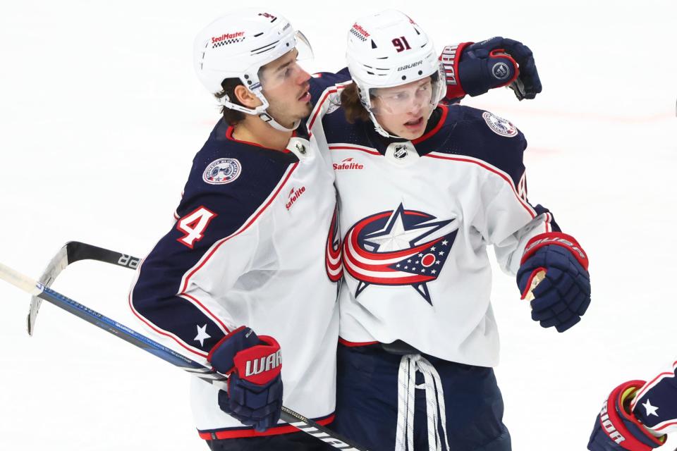 Columbus Blue Jackets center Kent Johnson (91) celebrates his goal against the Buffalo Sabres with forward Cole Sillinger (4) during the third period of an NHL hockey game Tuesday, Dec. 19, 2023, in Buffalo, N.Y. (AP Photo/Jeffrey T. Barnes)