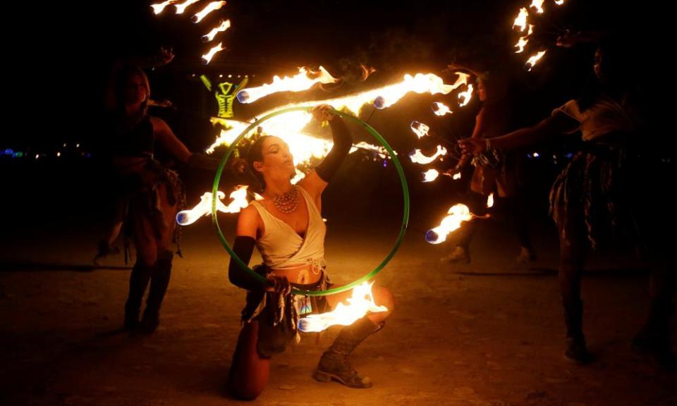 Members of the Revolutionary Motion fire conclave spin fire hoops at Burning Man in 2017.