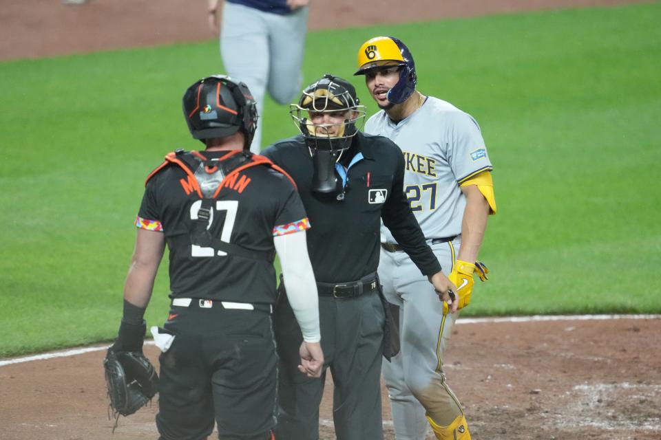 Brewers shortstop Willy Adames and Orioles catcher James McCann exchange words as home plate umpire Adam Hamari gets between them during the sixth inning Friday night.