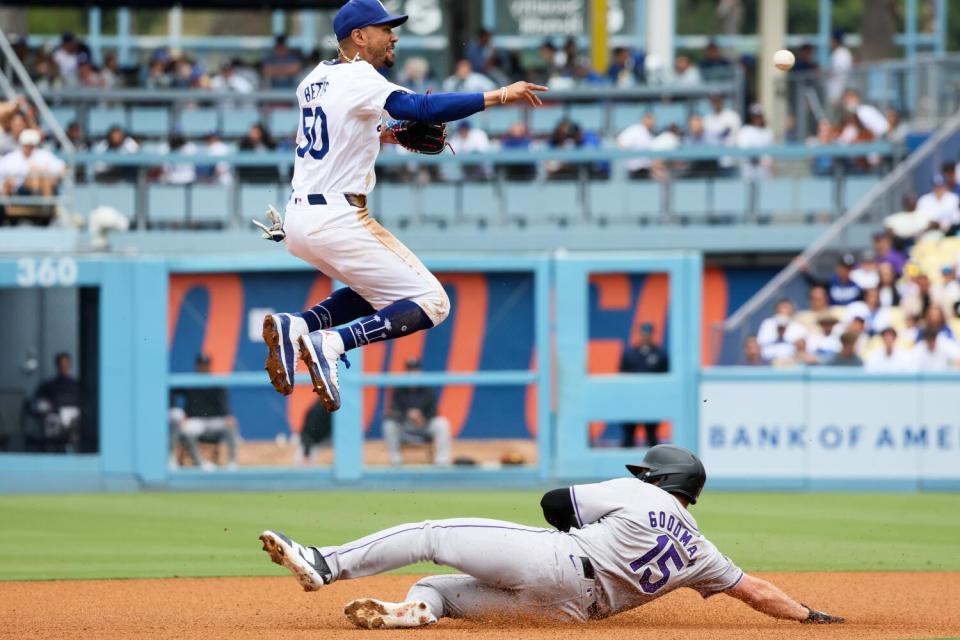 Dodgers shortstop Mookie Betts jumps over Colorado's Hunter Goodman after throwing to first base in the first inning on Sunday.