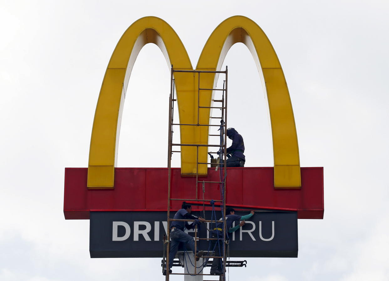 Workers repair the logo on a McDonald's sign in Paranaque, Metro Manila October 6, 2015. Picture taken October 6, 2015. REUTERS/Erik De Castro