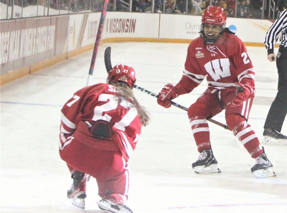 Wisconsin's Kirsten Simms (27) and Chayla Edwards celebrate after Simms scored during the first period of the team's national final with Ohio State on Sunday at AMSOIL Arena in Duluth, Minn.