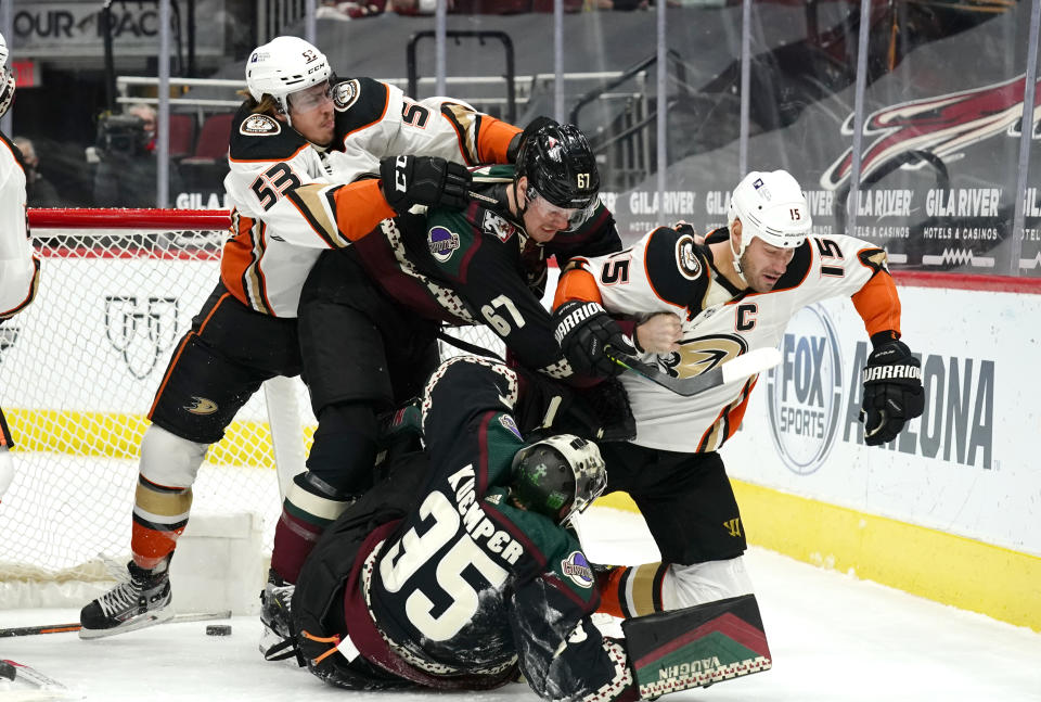 Anaheim Ducks left wing Max Comtois (53) and center Ryan Getzlaf (15) fight with Arizona Coyotes left wing Lawson Crouse (67) and goaltender Darcy Kuemper (35) in the first period during an NHL hockey game, Monday, Feb. 22, 2021, in Glendale, Ariz. (AP Photo/Rick Scuteri)