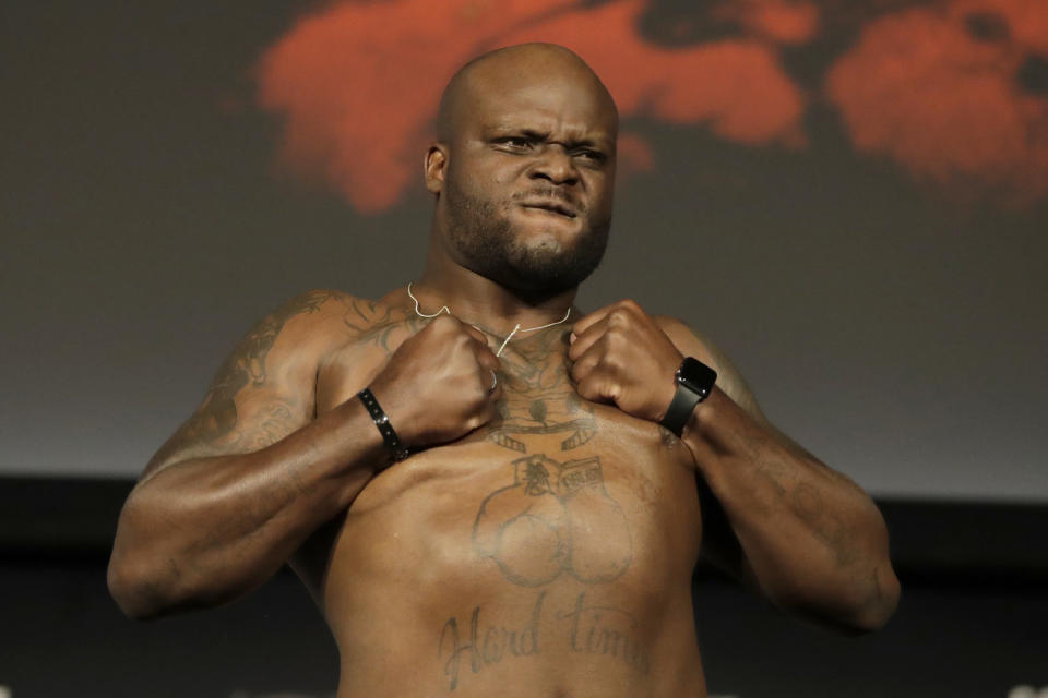 Derrick Lewis reacts while posing atop a scale prior to his heavyweight mixed martial arts bout against Daniel Cormier during the weigh-ins ahead of UFC 230, Friday, Nov. 2, 2018, at Madison Square Garden in New York. (AP Photo/Julio Cortez)