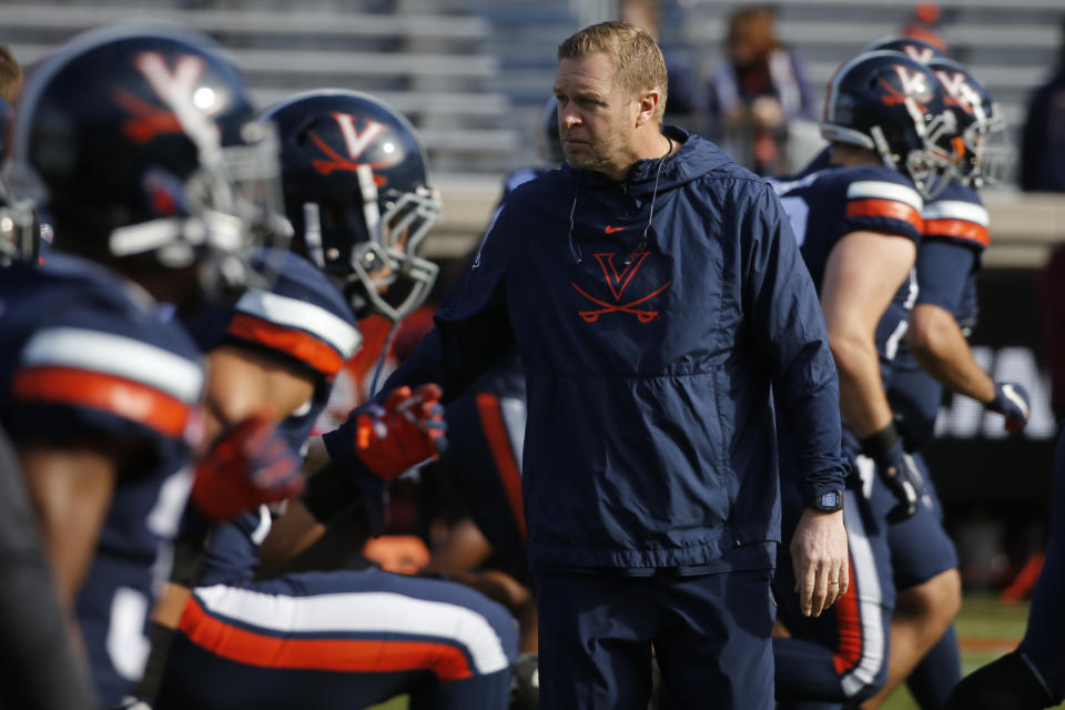 Virginia head coach Bronco Mendenhall watches his team warm up before an NCAA college football game against Virginia Tech in Charlottesville, Va., Friday, Nov. 29, 2019. (AP Photo/Steve Helber)