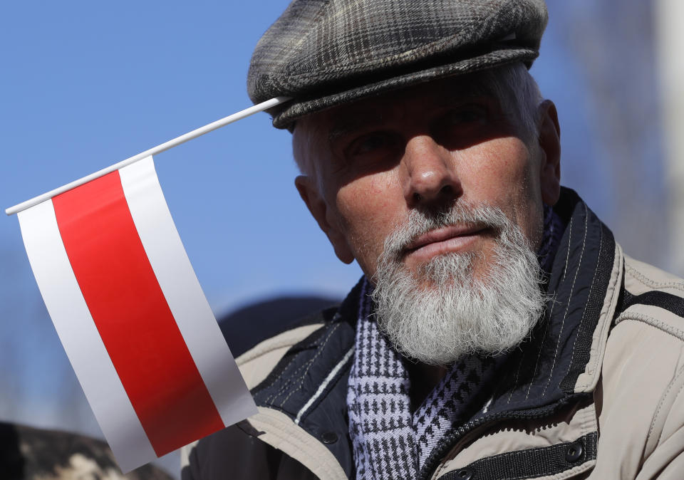 A man with an old Belarus republic flag attached in his cap attends celebrations in Minsk, Belarus, Sunday, March 24, 2019, on the eve of March 25, a traditional day of demonstration for the opposition. Many people gather to mark what they call Freedom Day, on the 101st anniversary of the 1918 declaration of the first, short-lived independent Belarus state, the Belarusian People's Republic lasted until 1919. (AP Photo/Sergei Grits)