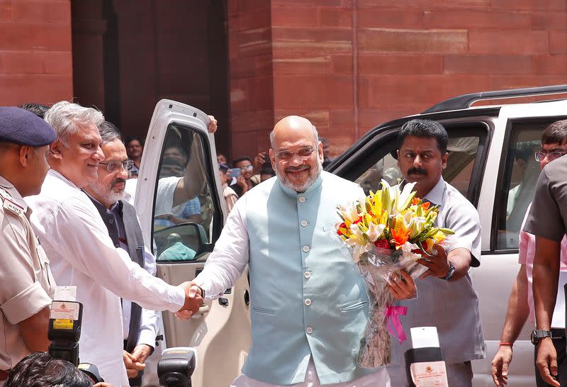 FILE PHOTO: India's newly appointed Home Minister Amit Shah receives a flower bouquet upon his arrival at the home ministry in New Delhi