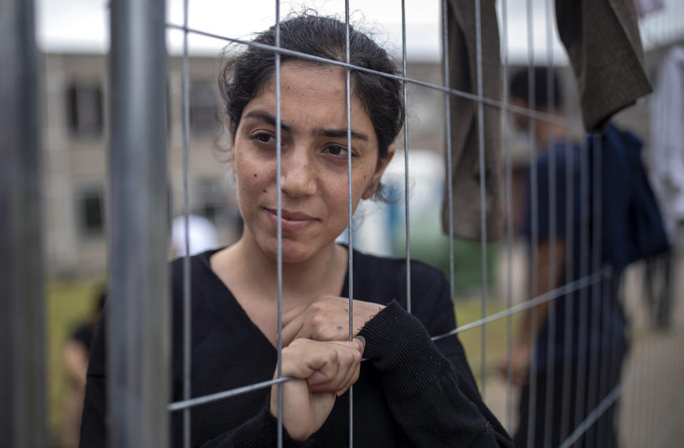 Saqd Ado, a migrants from Iraq, stands at the fence at the refugee camp in the village of Verebiejai, some 145km (99,1 miles) south from Vilnius, Lithuania, Sunday, July 11, 2021. Migrants at the school in the village of Verebiejai, about 140 kilometers (87 miles) from Vilnius, haven't been allowed to leave the premises and are under close police surveillance. Some have tested positive for COVID-19 and have been isolated in the building. (AP Photo/Mindaugas Kulbis)