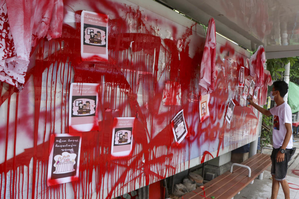 An anti-coup protester uses red paint as he writes slogans at a bus stop on Wednesday April 14, 2021 in Yangon, Myanmar. Anti-coup protesters kept public demonstrations going despite the threat of lethal violence from security forces. The words reads "We do not accept military coup". (AP Photo)