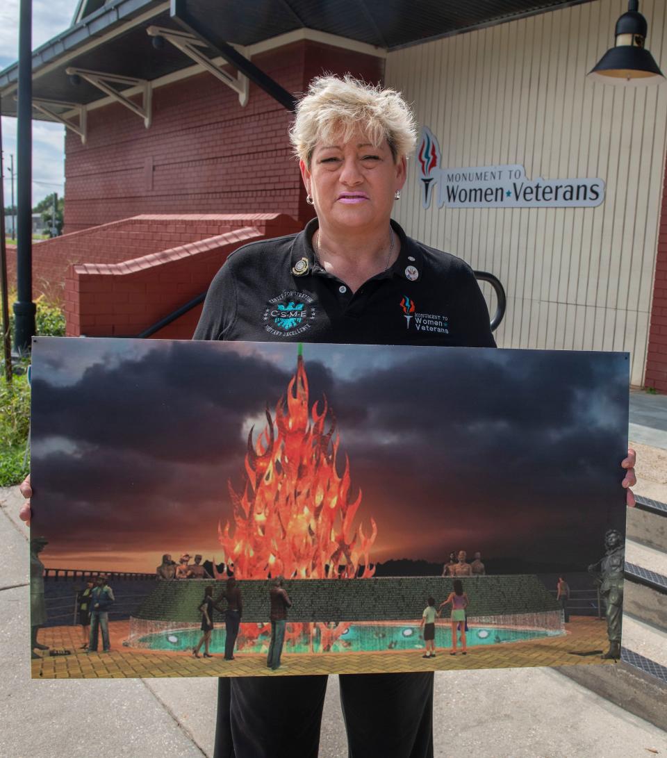 Michelle Caldwell, founder of the Monument to Women Veterans, holds a rendering of the monument. The finished monument will feature a flame rising more than 30 feet into the air and include a stainless-steel elliptical band of flowing water.