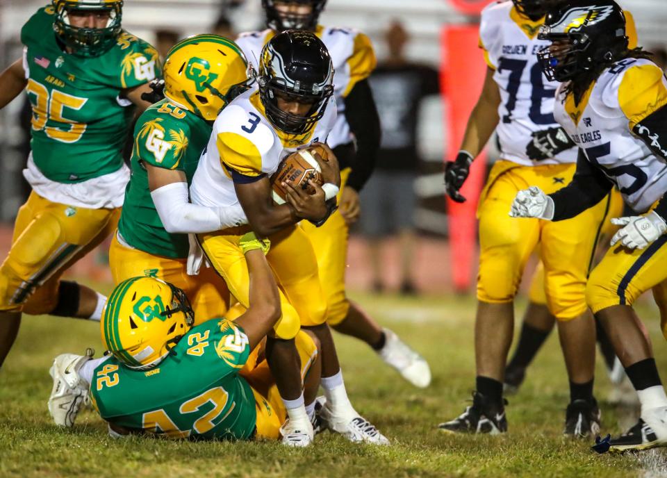 Desert Hot Springs' Messiah Smith (3) runs the ball as he's hit by Coachella Valley's Juan Marquez (42) and Hector Figueroa (69) during the first quarter of their game at Coachella Valley High School in Thermal, Calif., Friday, Sept. 22, 2023.