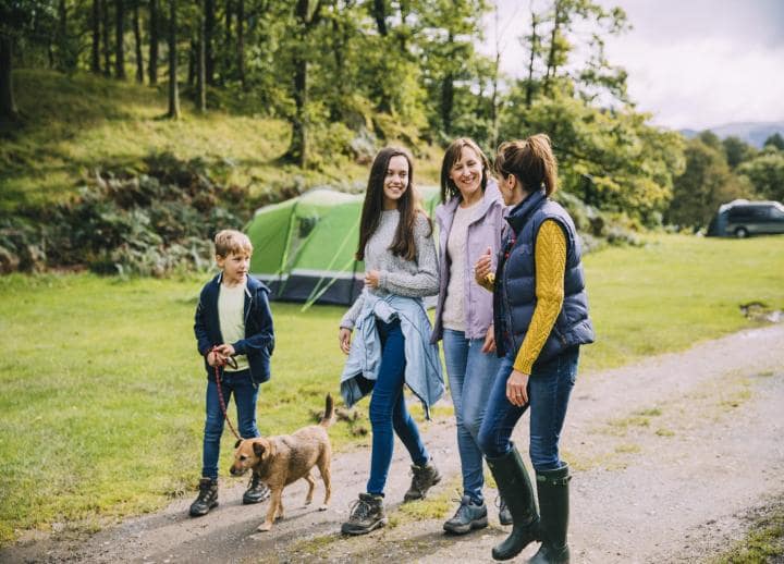 Family walking a dog along a campground