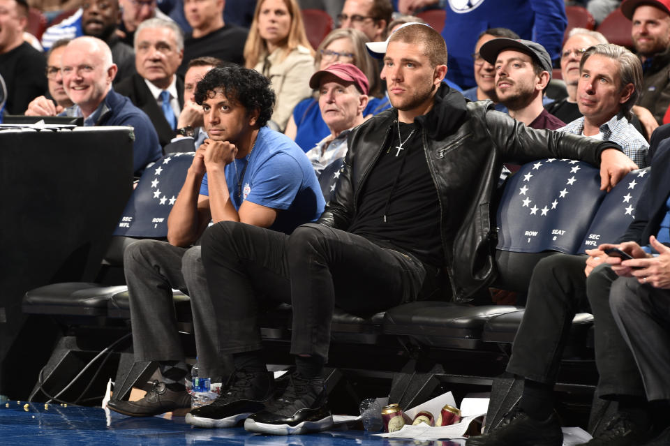 M. Night Shyamalan and NFL player Zach Ertz attend Game Two of Round One between the Brooklyn Nets and the Philadelphia 76ers during the 2019 NBA Playoffs on April 15, 2019 at the Wells Fargo Center in Philadelphia, Pennsylvania. (Photo by David Dow/NBAE via Getty Images)