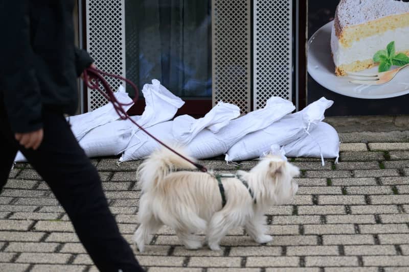 Sandbags lie in front of the windows of a hotel in the spa town of Rathen in Saxon Switzerland. The first water level on the Elbe in Saxony has reached alarm level 2. In Schöna, the corresponding guideline value of 5 meters was exceeded in the early morning, according to data from the State Flood Centre. Robert Michael/dpa