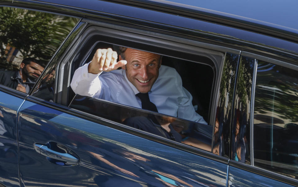 French President Emmanuel Macron waves from his car as he leaves a vocational school in Orange, Southeastern France, Friday, Sept. 1, 2023. (Ludovic Marin/Pool via AP)