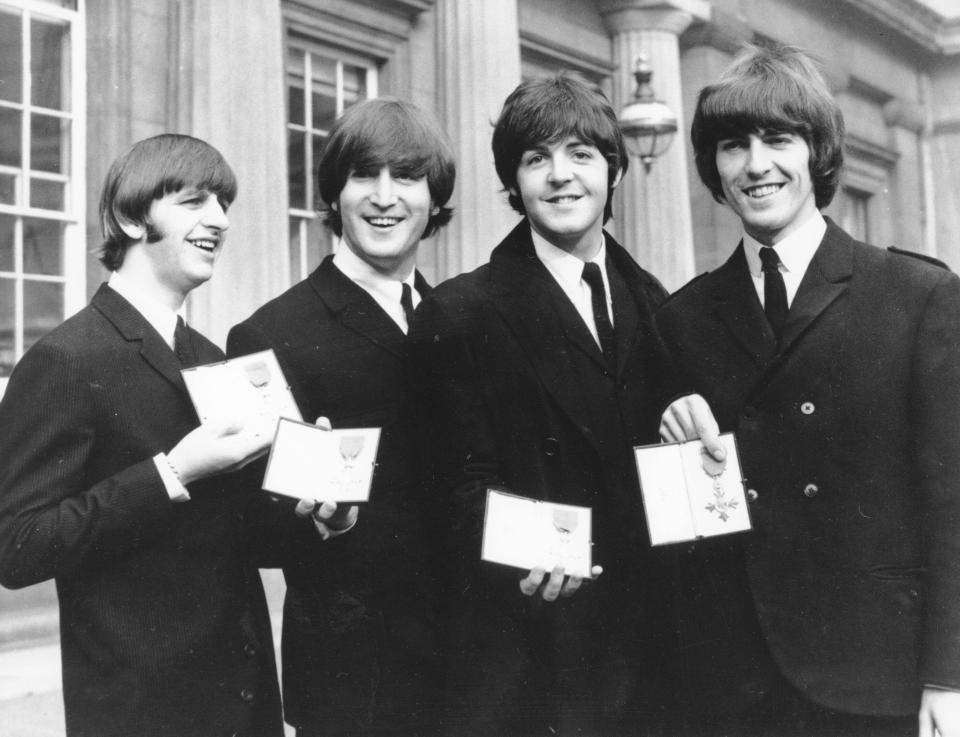 The Beatles smile as they display the Member of The Order of The British Empire medals presented to them by Queen Elizabeth II in a ceremony in Buckingham Palace in London, England on Oct. 26, 1965. Left to right are Ringo Starr, John Lennon, Paul McCartney and George Harrison. (AP Photo)