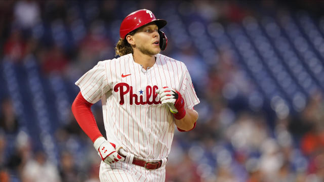 Philadelphia Phillies - Alec Bohm smiling, while putting on his