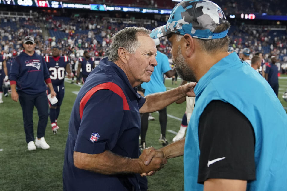 New England Patriots coach Bill Belichick, center, greets Carolina Panthers coach Matt Rhule on the field following a preseason NFL football game Friday, Aug. 19, 2022, in Foxborough, Mass. (AP Photo/Charles Krupa)