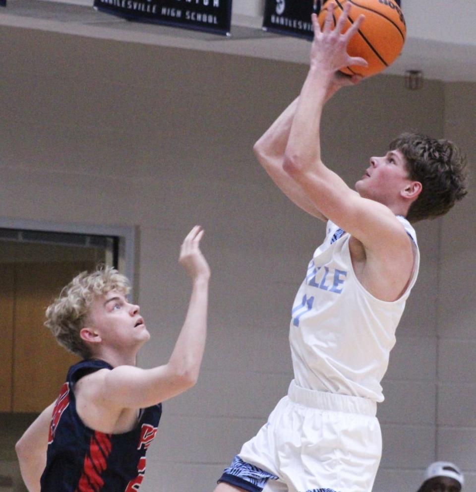 Bartlesville High guard Dayton McCall, left, drops in a shot  during Bartlesville tourney action on Jan. 5, 2023.