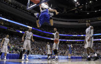 FILE - In this March 22, 2013, file photo, Florida Gulf Coast's Chase Fieler (20) hangs from the rim after a dunk as Georgetown's Markel Starks (5), Otto Porter Jr. (22), D'Vauntes Smith-Rivera (4), Mikael Hopkins (3) and Aaron Bowen (23) look on during the second half of a second-round game of the NCAA college basketball tournament n Philadelphia. Florida Gulf Coast won 78-68. The Dunk City Effect, as it's called, accounted for a 35 percent increase in freshman applications following the NCAA run, boosted enrollment from about 13,000 to more than 15,000, and the academic reputation has been enhanced with higher caliber students being admitted. (AP Photo/Matt Rourke, File)