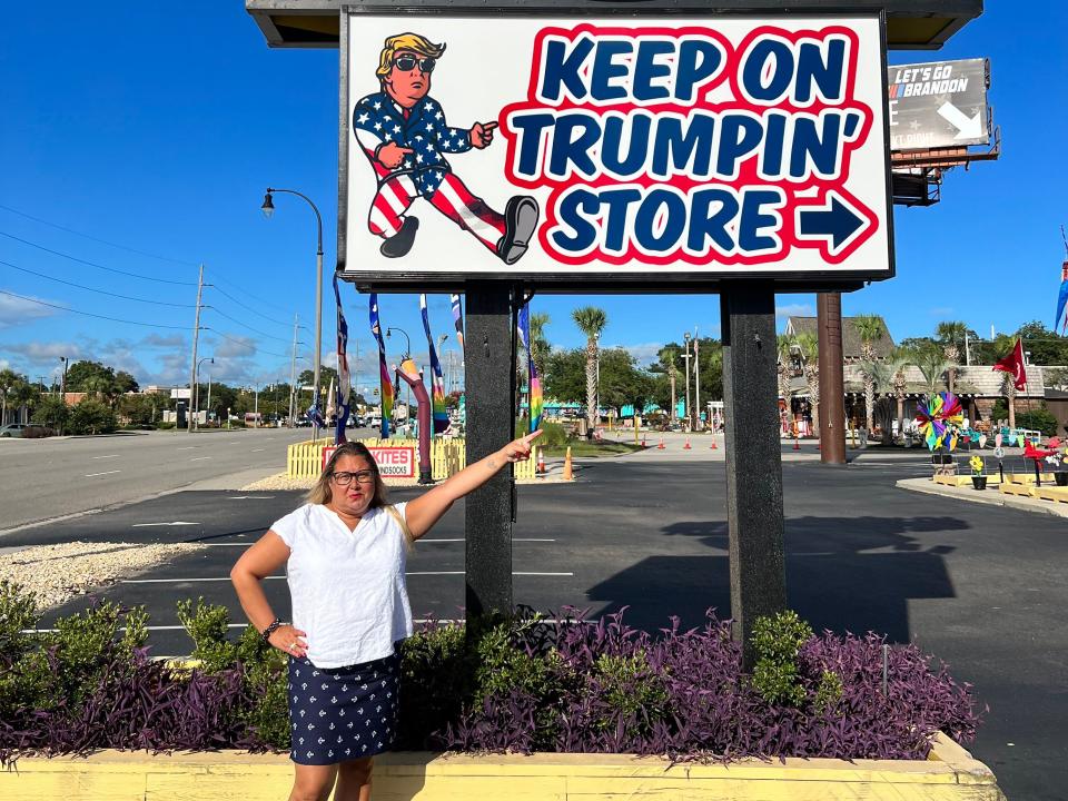 Jenny Powers in front of the Trump Superstore sign.