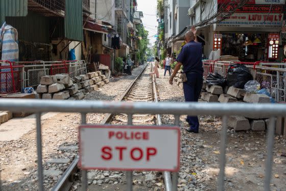 Railroad staff ask tourists who have sneaked past the barrier to leave Train Street on September 19, 2022. <span class="copyright">Chris Humphrey—picture alliance/Getty Images</span>