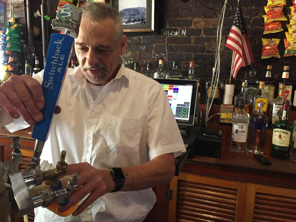 David Hunter, manager at Esox, pours a beer at the Burlington bar July 20, 2021.