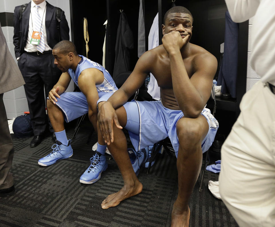 North Carolina's Denzel Robinson, left, and Joel James, right, sit in the locker room after the team's loss to Iowa State in a third-round game in the NCAA college basketball tournament Sunday, March 23, 2014, in San Antonio. Iowa State won 85-83. (AP Photo/Eric Gay)