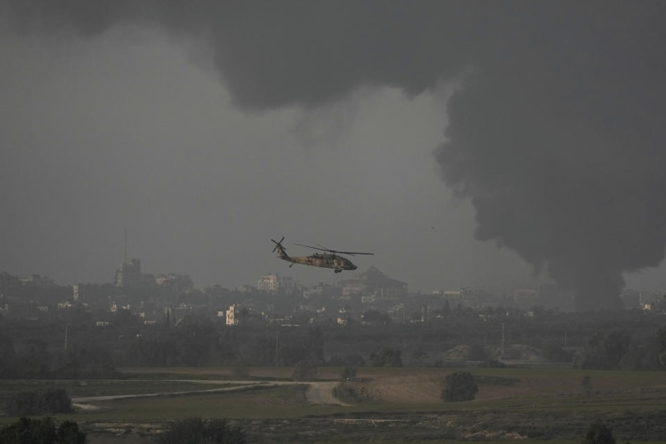 An Israeli military helicopter flies near the Israeli-Gaza border, as seen from southern Israel, Monday, Jan. 1, 2024. The army is battling Palestinian militants across Gaza in the war ignited by Hamas' Oct. 7 attack into Israel. (AP Photo/Leo Correa)