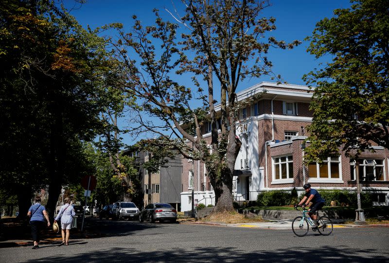 People walk and bike in the Greek Row area at the University of Washington in Seattle