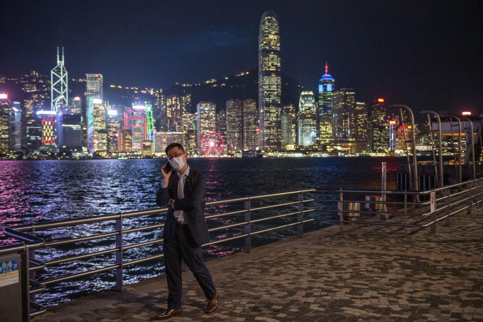 FILE - A man talks on his phone in front of the skyline in Hong Kong, Oct. 19, 2022. Hong Kong government supporters have expanded their reach to defend a tough national security law imposed by China's ruling Communist Party at the United Nations, raising concerns over their influence on shaping the world's understanding of the city. (AP Photo/Vernon Yuen, File)