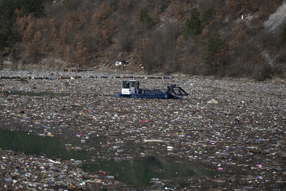 A machine collects garbage from the Drina river near Visegrad, eastern Bosnia, Wednesday, Feb. 24, 2021. Environmental activists in Bosnia are warning that tons of garbage floating down the Balkan country's rivers are endangering the local ecosystem and people's health. The Drina River has been covered for weeks with trash that has piled up faster than the authorities can clear it out. (AP Photo/Kemal Softic)