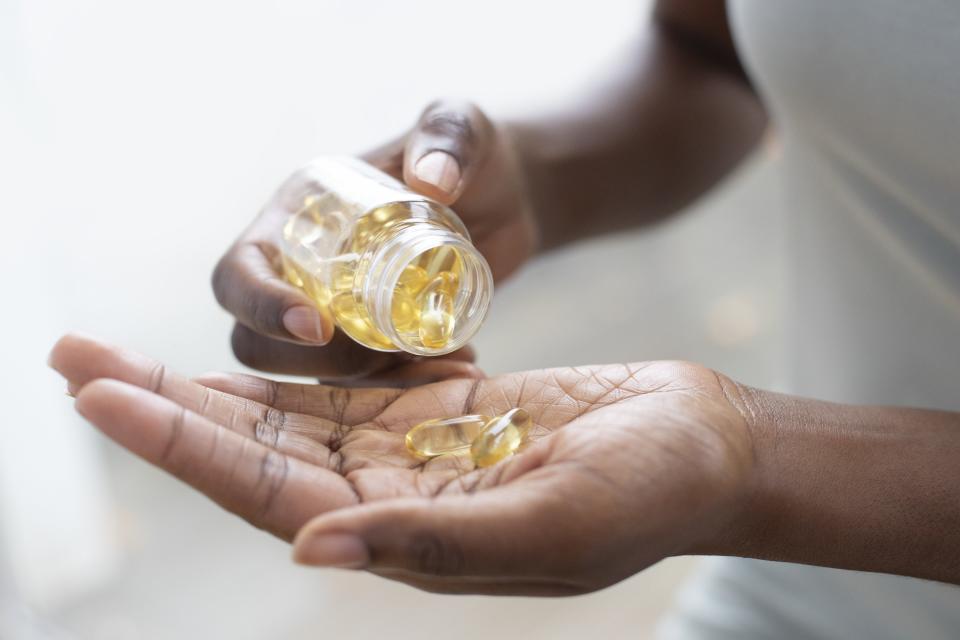 Woman pouring capsules into her hand