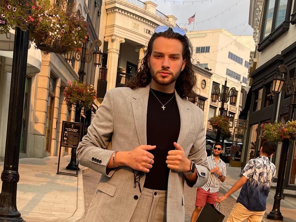 Bryan Whitman, a TikTok influencer, poses in a street wearing a suit.