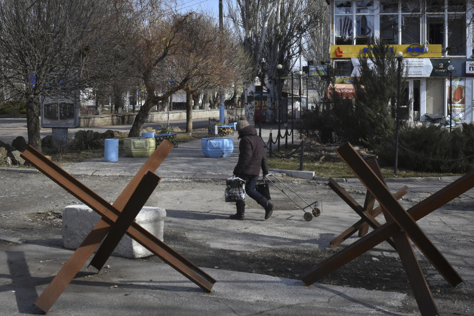 A local resident walks along a street in Orihiv, Zaporizhzhya region, Ukraine, Friday, Feb. 24, 2023. Ukraine's president pledged to push for victory in 2023 as he and other Ukrainians on Friday marked the somber first anniversary of the Russian invasion that he called "the longest day of our lives." (AP Photo/Andriy Andriyenko)