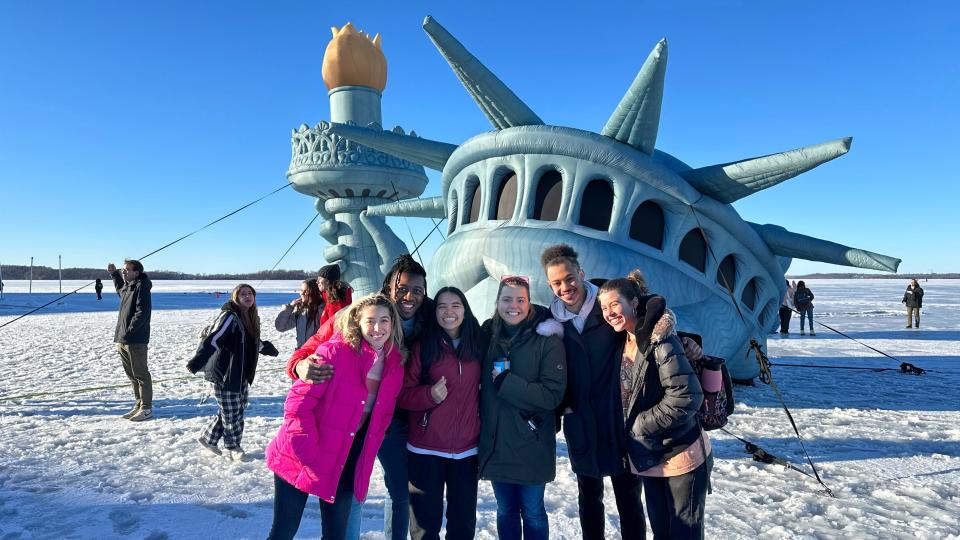 Wisconsin Union Winter Carnival attendees pose with Lady Liberty on Lake Mendota in 2023, a favorite tradition of the annual festival.