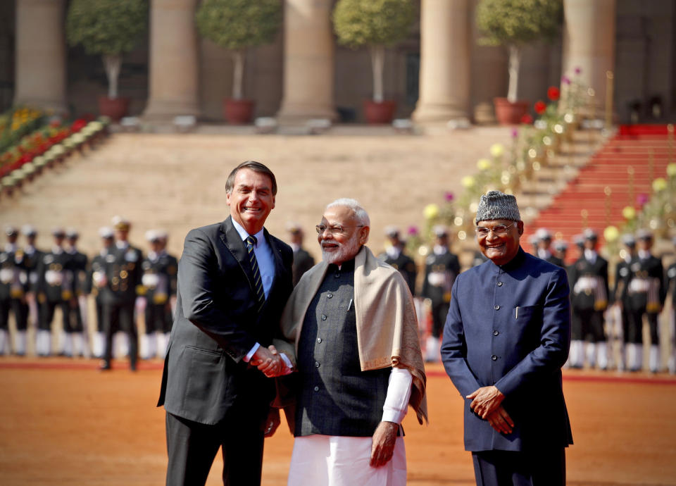 Brazil's President Jair Bolsonaro, left, shakes hand with Indian Prime Minister Narendra Modi, with Indian President Ram Nath Kovind standing beside them during his ceremonial welcome at the presidential palace in New Delhi, India, Saturday, Jan. 25, 2020. Bolsonaro is this year's chief guest for India's Republic day parade. (AP Photo/Manish Swarup)