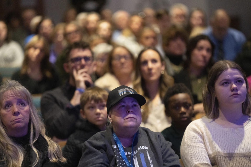 Jami Carlson joins hundreds of community members as they watch a live stream of a memorial service for Burnsville police officers Paul Elmstrand, 27, Matthew Ruge, 27, and firefighter-paramedic Adam Finseth, 40, at Prince of Peace in Burnsville, Minn., on Wednesday, Feb. 28, 2024. (Alex Kormann/Star Tribune via AP)