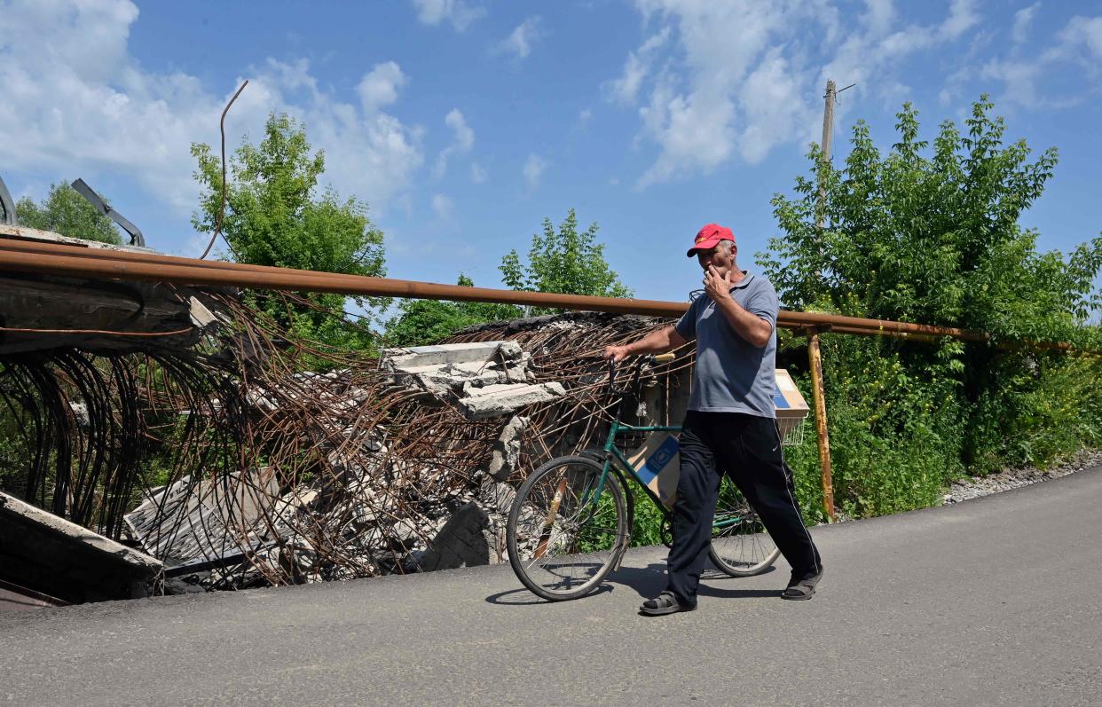 A man carries boxes with food sets of the UN World Food Program, distributed by volunteers as humanitarian aid to local residents of Liptsy village, Kharkiv region (AFP via Getty Images)