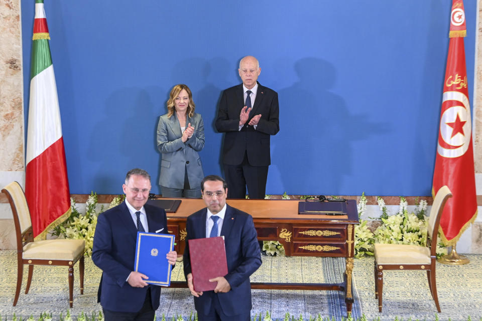 In this photo provided by the Tunisian Presidency, Tunisian President Kais Saied, rear right, and Italian Prime Minister Giorgia Meloni, applaud after the signing of an agreement by Italian deputy Foreign Minister Edmondo Cirielli, left, in Tunis, Wednesday April 17, 2024. Meloni and Saied signed new accords part of Italy's larger "Mattei Plan" for Africa, a continent-wide strategy aimed at growing economic opportunities and preventing migration from Africa to Europe. (Slim Abid/ Tunisian Presidential Palace via AP)