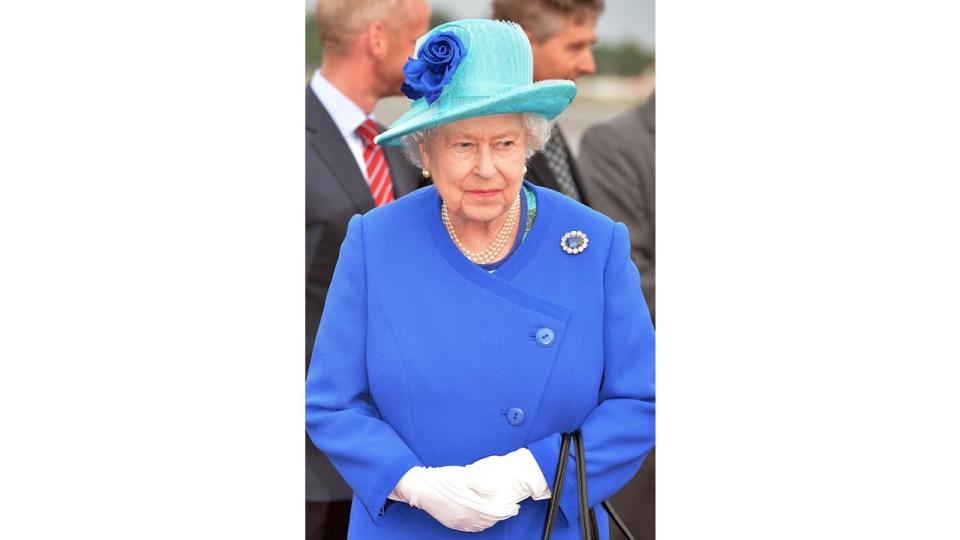 Queen Elizabeth in blue outfit and white gloves
