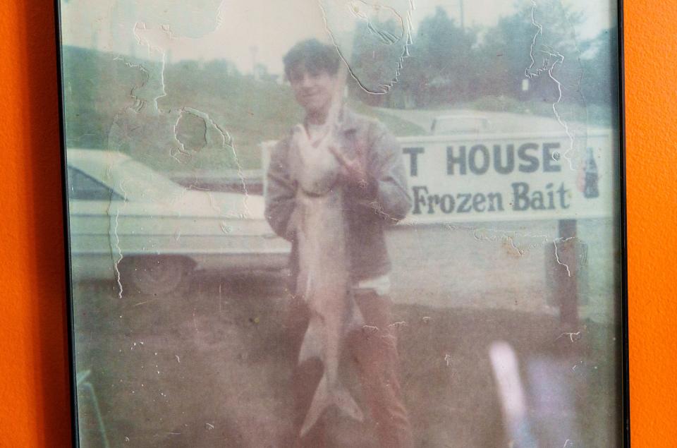 A photo of a young David Cox holding a paddlefish hangs Sunday, April 16, 2023, inside a memory room near he and wife Vicki's antique store in English, Indiana. Cox climbed his way up from high school dropout to become a successful entrepreneur who sold tons of Hoosier caviar to customers around the globe. He learned the trade from Vicki's father. Cox was sentenced in November 2018 to two years in prison after pleading guilty to federal gun and wildlife charges. Now out of prison, Cox recently completed his first season back on the Ohio River netting paddlefish.